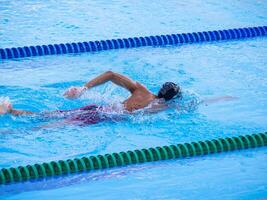 ein jung Mann Schwimmen im ein draussen Schwimmbad. Nahansicht Foto. Konzept von Sport und Gesundheitswesen foto