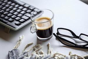 ein Tasse von belebend Kaffee beim das Arbeitsplatz foto