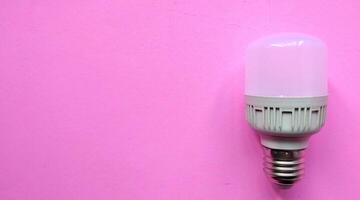 LED Licht Birne auf Rosa Hintergrund, Elektrizität und Energie Speichern Konzept. foto