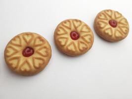 Kekse mit Erdbeere Marmelade auf ein Weiß Hintergrund, schließen oben foto