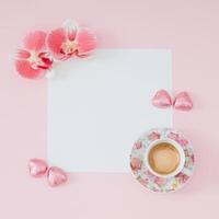 kreativ modisch Layout gemacht mit Tasse von Kaffee, Orchidee Blumen, Rosa vereiteln eingewickelt Schokolade Herzen und Papier Karte Hinweis Kopieren Raum auf Licht Rosa Hintergrund. minimal Konzept. eben legen. foto