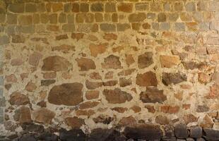 Textur einer Steinmauer mit vielen großen braunen und grauen Steinen, die mit Zement bewaffnet sind. alte Burg Steinmauer Textur Hintergrund für mittelalterliche Nutzung. Teil eines steinernen Gebäudes foto