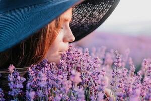 Frau Lavendel Feld. glücklich sorglos Frau im schwarz Kleid und Hut mit groß Rand riechen ein Blühen Lavendel auf Sonnenuntergang. perfekt zum inspirierend und warm Konzepte im Reise und Fernweh. schließen oben foto