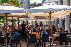 Ljubjana, Slowenien - - 17 August, 2019 - - Menschen haben Mittagessen im verpackt Restaurants während ein heiß Tag im das Hauptstadt foto