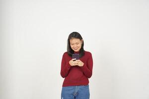 jung asiatisch Frau im rot T-Shirt Lächeln während mit Smartphone, SMS Konzept isoliert auf Weiß Hintergrund foto