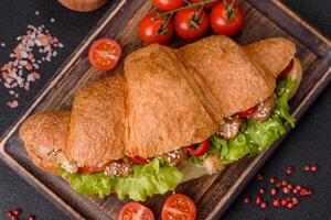 köstlich frisch knusprig Croissant mit Hähnchen oder Rindfleisch Fleisch, Kopfsalat, Tomaten, Gewürze und Soße foto