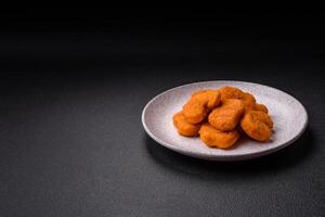 Köstliche, frische, knusprige Hühnernuggets auf dunklem Betonhintergrund foto