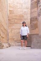 Frau Reisender erforscht das Ruinen von das uralt Karnak Tempel im das Stadt von Luxus im Ägypten. foto