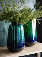 ai generiert bunt dekorativ Glas Vase mit Grün und Blau Muster auf das Tisch. schließen hoch. ai generativ foto