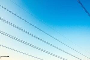 das elektrisch Kabel Kreuz das Blau Himmel foto