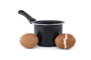 Kochen Topf Umgebung Eier, einer geknackt während Sieden foto