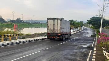 ein groß Box LKW geht vorbei durch auf ein ruhig Straße foto