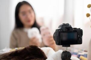 ein Nahansicht Bild von ein Kamera Aufzeichnung ein weiblich Inhalt Schöpfer Influencer beim heim. foto