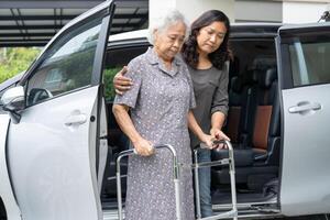 asiatisch Senior Frau geduldig Sitzung auf Gehhilfe bereiten erhalten zu ihr Auto, gesund stark medizinisch Konzept. foto