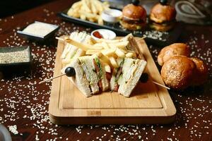 hölzern Schneiden Tafel mit Hälfte Sandwich und Französisch Fritten foto