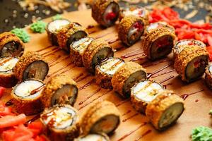 hölzern Schneiden Tafel mit Sushi und Gemüse foto