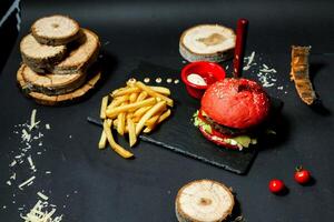 köstlich Hamburger und Französisch Fritten auf ein Schneiden Tafel foto