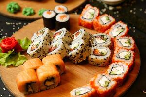hölzern Teller mit Sushi und Gemüse foto
