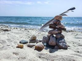 ein Gruppe von Meer Steine auf das Sand in der Nähe von Meer. foto