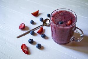 das Obst Smoothie im ein Glas Tasse, und reif Früchte auf das Tisch. foto