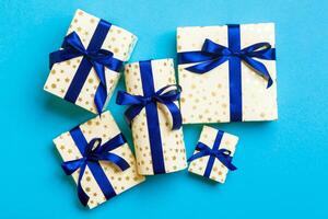 eingewickelt Weihnachten oder andere Urlaub handgemacht Geschenk im Papier mit Blau Band auf Blau Hintergrund. Geschenk Kasten, Dekoration von Geschenk auf farbig Tisch, oben Aussicht foto