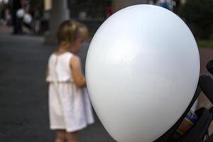 Weiß Ballon Nahansicht und Kinder spielen im das Hintergrund. foto