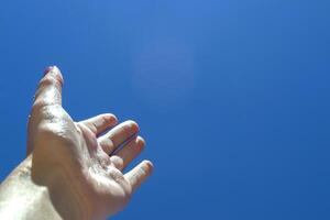 weiblich Arm gegen ein Blau Himmel Hintergrund. foto