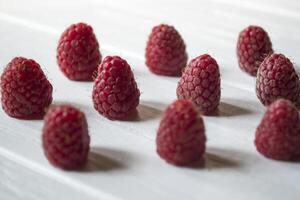 reif Himbeeren auf ein Weiß hölzern Hintergrund. foto