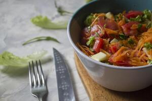 das Schüssel von organisch Salat und Besteck auf ein Tisch. foto