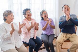 Senior Frauen und männlich Sitzung auf Bank. älter Menschen sind Hören und genießen Treffen Fokus Gruppe beim Leben Zimmer. froh sorglos im Ruhestand Senior freunde genießen Entspannung beim fast heim. foto