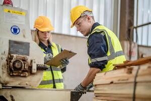 Arbeiter Tischler Arbeiten im Maschinen zu Schnitt Holz Holz. Mann und Frau sind basteln mit Holz im ein Werkstatt. zwei Handwerker oder Handwerker Arbeiten mit Zimmermann Werkzeuge oder elektrisch Maschinen. foto