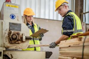 Arbeiter Tischler Arbeiten im Maschinen zu Schnitt Holz Holz. Mann und Frau sind basteln mit Holz im ein Werkstatt. zwei Handwerker oder Handwerker Arbeiten mit Zimmermann Werkzeuge oder elektrisch Maschinen. foto