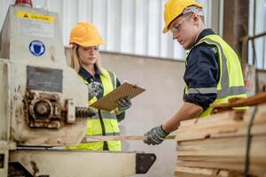 Arbeiter Tischler Arbeiten im Maschinen zu Schnitt Holz Holz. Mann und Frau sind basteln mit Holz im ein Werkstatt. zwei Handwerker oder Handwerker Arbeiten mit Zimmermann Werkzeuge oder elektrisch Maschinen. foto