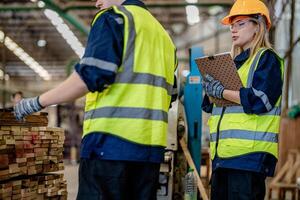 Arbeiter Tischler Arbeiten im Maschinen zu Schnitt Holz Holz. Mann und Frau sind basteln mit Holz im ein Werkstatt. zwei Handwerker oder Handwerker Arbeiten mit Zimmermann Werkzeuge oder elektrisch Maschinen. foto