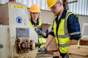 Arbeiter Tischler Arbeiten im Maschinen zu Schnitt Holz Holz. Mann und Frau sind basteln mit Holz im ein Werkstatt. zwei Handwerker oder Handwerker Arbeiten mit Zimmermann Werkzeuge oder elektrisch Maschinen. foto