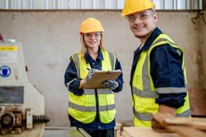 Arbeiter Tischler Arbeiten im Maschinen zu Schnitt Holz Holz. Mann und Frau sind basteln mit Holz im ein Werkstatt. zwei Handwerker oder Handwerker Arbeiten mit Zimmermann Werkzeuge oder elektrisch Maschinen. foto