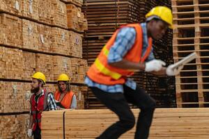 afrikanisch Arbeitskräfte Mann Ingenieurwesen Gehen und inspizieren mit Arbeiten Suite Kleid und Hand Handschuh im Bauholz Holz Lagerhaus. Konzept von Clever Industrie Arbeiter Betriebs. Holz Fabriken produzieren Holz Gaumen. foto