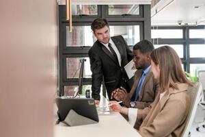 vielfältig Angestellte versammelt im Büro haben Spaß während Brainstorming während diskutieren Neu Ideen Projekt. gemischtrassig Mitarbeiter Treffen beim Coworking Raum Bereich. Mannschaft von jung Menschen im Büro. foto