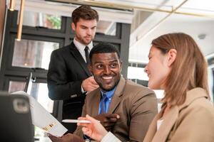 vielfältig Angestellte versammelt im Büro haben Spaß während Brainstorming während diskutieren Neu Ideen Projekt. gemischtrassig Mitarbeiter Treffen beim Coworking Raum Bereich. Mannschaft von jung Menschen im Büro. foto