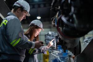 Ingenieure prüfen Steuerung schwer Maschine Roboter Arm. vielfältig Mannschaft von industriell Robotik Ingenieure versammelt um Maschine. Fachmann Maschinen Betreiber Reparatur elektrisch Roboter auf hell Digital Tafel. foto