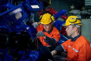 Geschäft Ingenieure Treffen und prüfen Steuerung schwer Maschine Roboter Arm. vielfältig Mannschaft von industriell Robotik Ingenieure versammelt um Maschine. Fachmann Maschinen Operator verwenden industriell Digital Tablette. foto