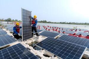 männlich Arbeitskräfte Reparatur schwebend Solar- Paneele auf Wasser See. Ingenieure konstruieren auf Seite? ˅ schwebend Solar- Paneele beim Sonne Licht. sauber Energie zum Zukunft Leben. industriell verlängerbar Energie von Grün Leistung. foto