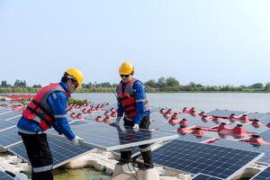 männlich Arbeitskräfte Reparatur schwebend Solar- Paneele auf Wasser See. Ingenieure konstruieren auf Seite? ˅ schwebend Solar- Paneele beim Sonne Licht. sauber Energie zum Zukunft Leben. industriell verlängerbar Energie von Grün Leistung. foto