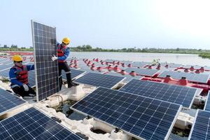 männlich Arbeitskräfte Reparatur schwebend Solar- Paneele auf Wasser See. Ingenieure konstruieren auf Seite? ˅ schwebend Solar- Paneele beim Sonne Licht. sauber Energie zum Zukunft Leben. industriell verlängerbar Energie von Grün Leistung. foto