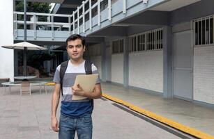 ein männlich Schüler beim das Universität halten ein Papier im seine Hand foto