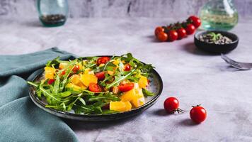 hausgemacht Salat von orange, Kirsche Tomaten und Rucola auf ein Teller Netz Banner foto