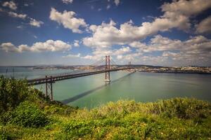 das 25 de Abril Brücke ist ein Brücke verbinden das Stadt von Lissabon zu das Gemeinde von Almada auf das links Bank von das tejo Fluss, Lissabon foto