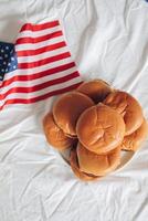 amerikanisch Flagge und Hamburger auf ein Weiß Tischdecke, oben Aussicht foto