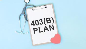 403b planen Zwischenablage mit Stethoskop und Herz gestalten auf Blau Hintergrund. Gesundheitswesen und medizinisch Pensionierung Planung Konzept. foto