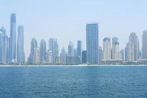 das Sonne scheint auf das städtisch direkt am Strand von Dubai, präsentieren das Hochhaus Lebensstil und die Architektur. Dubai, VAE - - August 15, 2023. foto